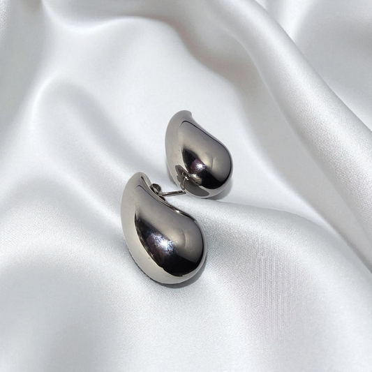 Aretes plateados en forma de gota.